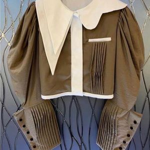 100% Cotton

Puffy Sleeves

Buttons on sleeves

Snaps down the middle